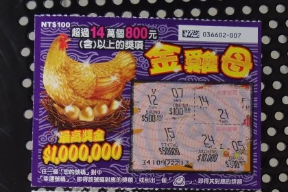 A colourful printed lottery ticket held up close to the camera