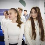 Students learning in a phone-free classroom with smartphones put away, illustrating a study on classroom bans and academic performance