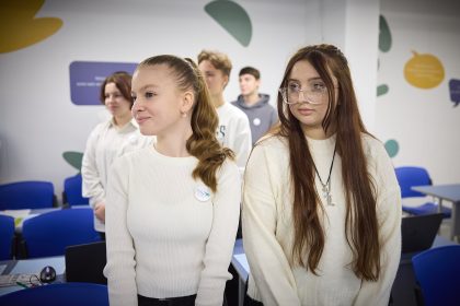 Students learning in a phone-free classroom with smartphones put away, illustrating a study on classroom bans and academic performance
